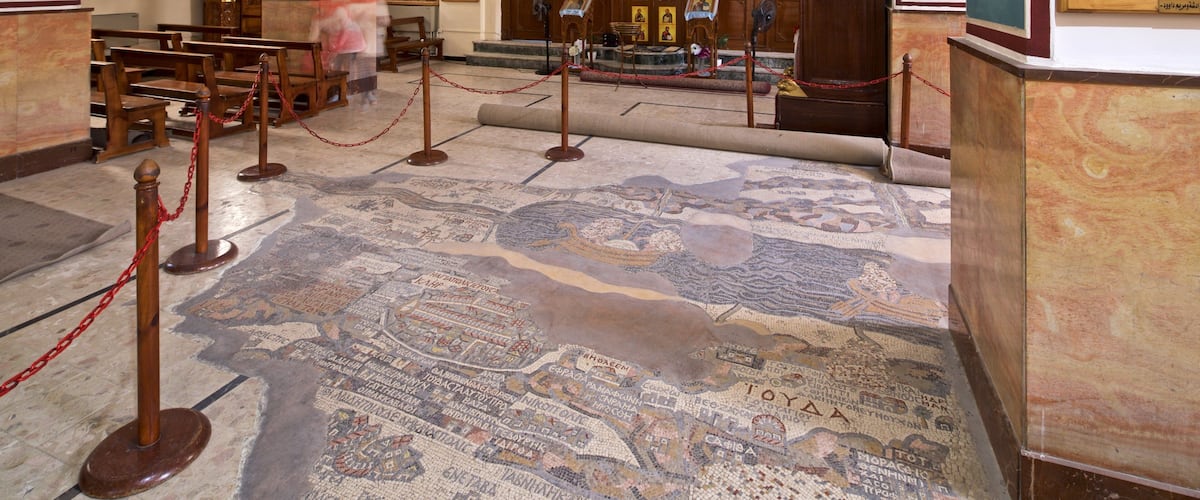 A mosaic floor with inscriptions and a wooden structure.