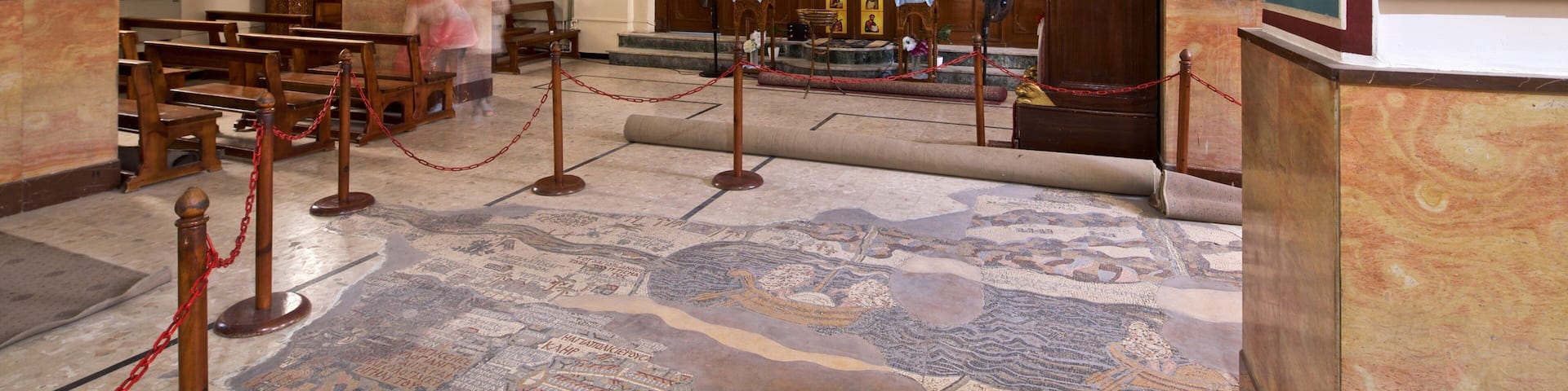 A mosaic floor with inscriptions and a wooden structure.