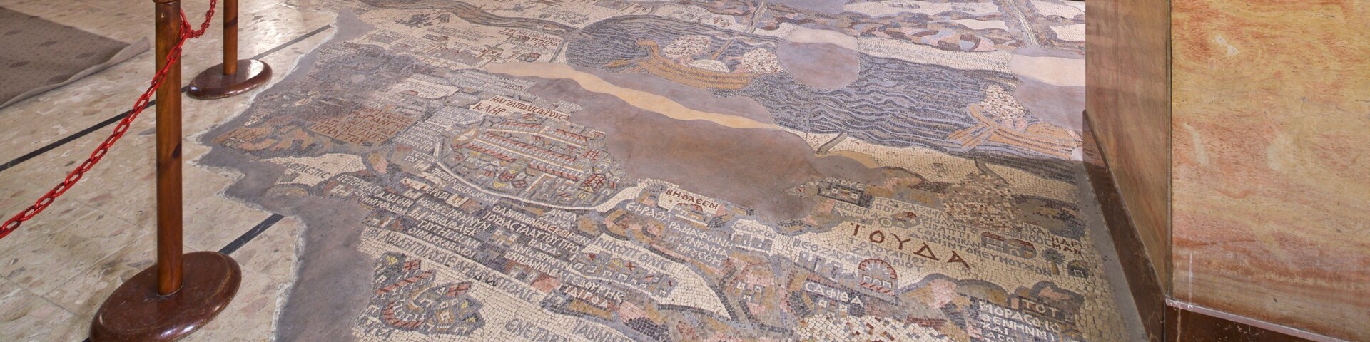 Piso em mosaico com inscrições e estrutura de madeira.