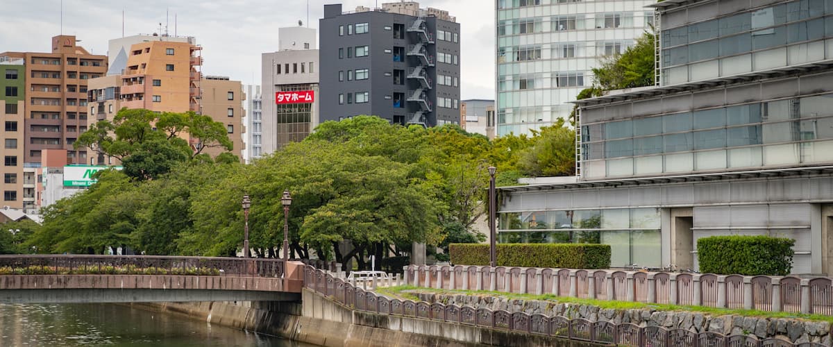 A cityscape with modern buildings, a river, and a bridge.