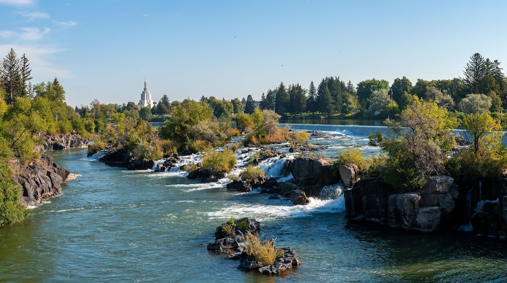 Panoramic view of scenic Idaho falls and Snake river. Beautiful tourist attraction in city. Picturesque natural scenery of flowing water amidst rocks and plants with sky in background.