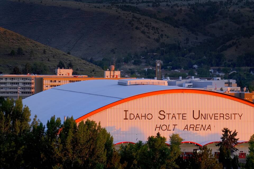 Idaho State University Holt Arena with a backdrop of hills and trees.