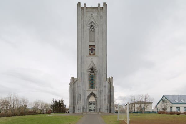 Eine hohe, schmale Kirche mit Spitzbogen und farbigen Glasfenstern.