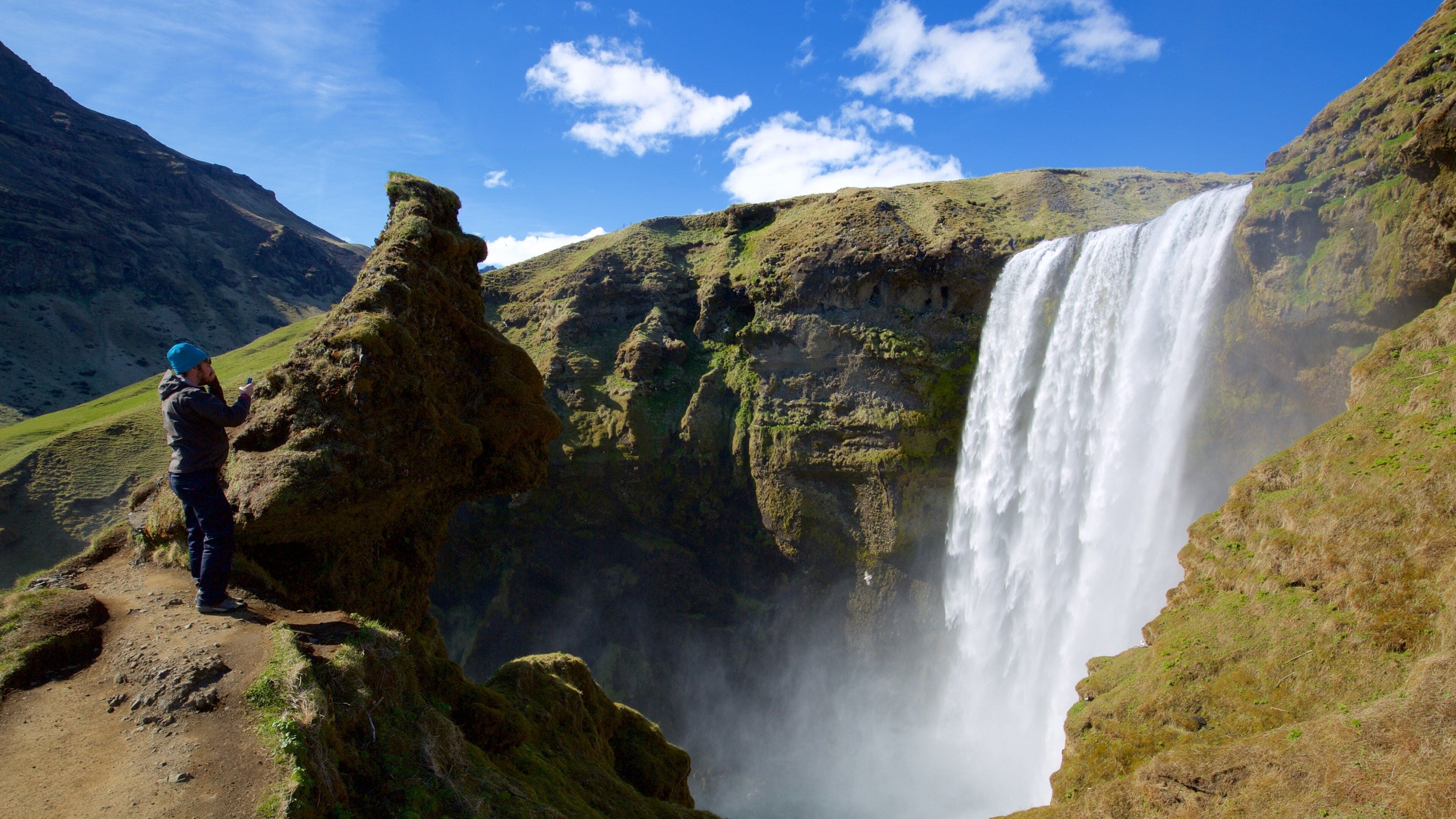 Skogafoss showing a cascade and a gorge or canyon as well as an individual male