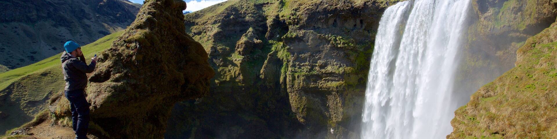 Skogafoss showing a cascade and a gorge or canyon as well as an individual male