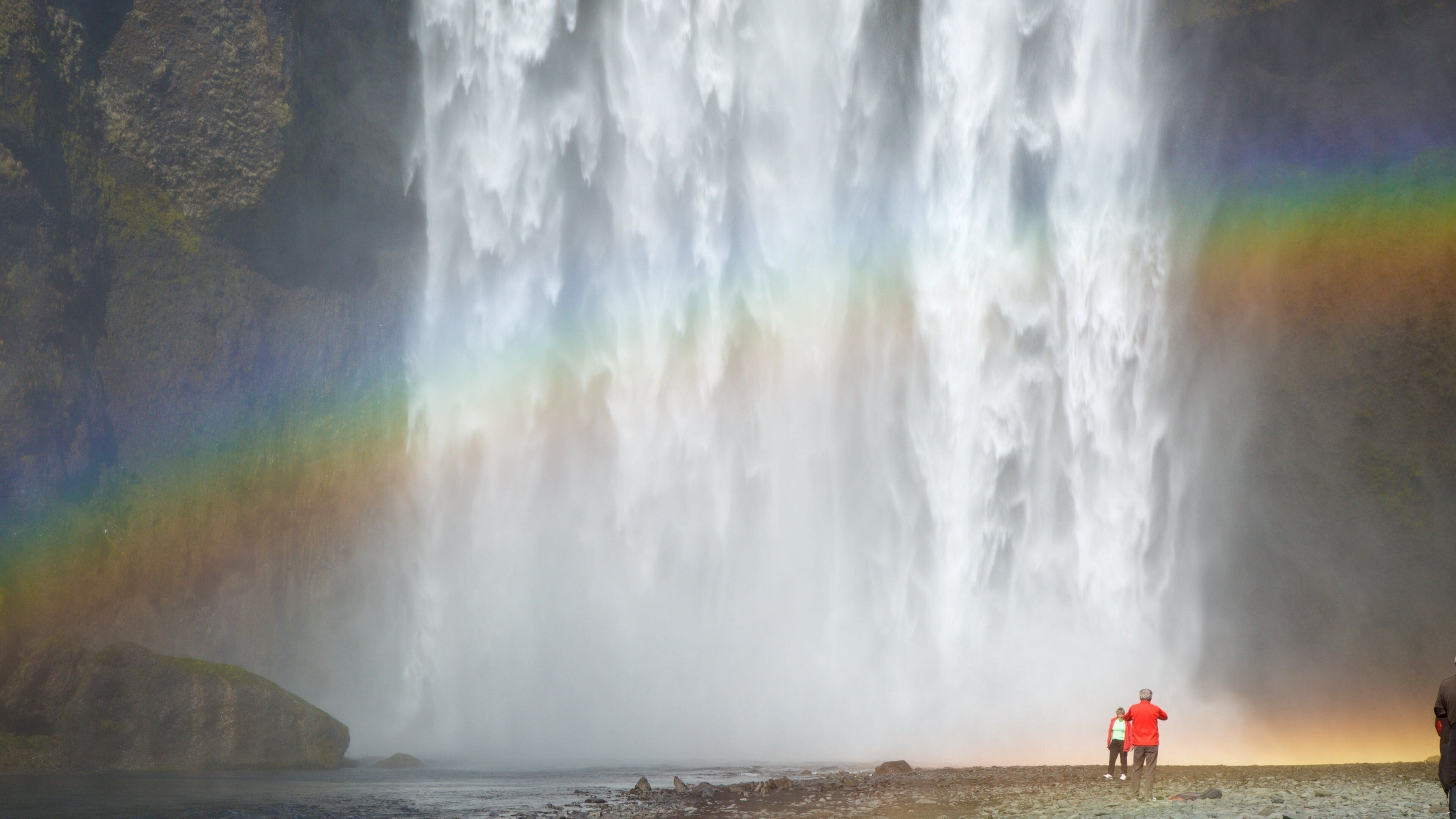 Skogafoss mostrando una cascada y también un pequeño grupo de personas