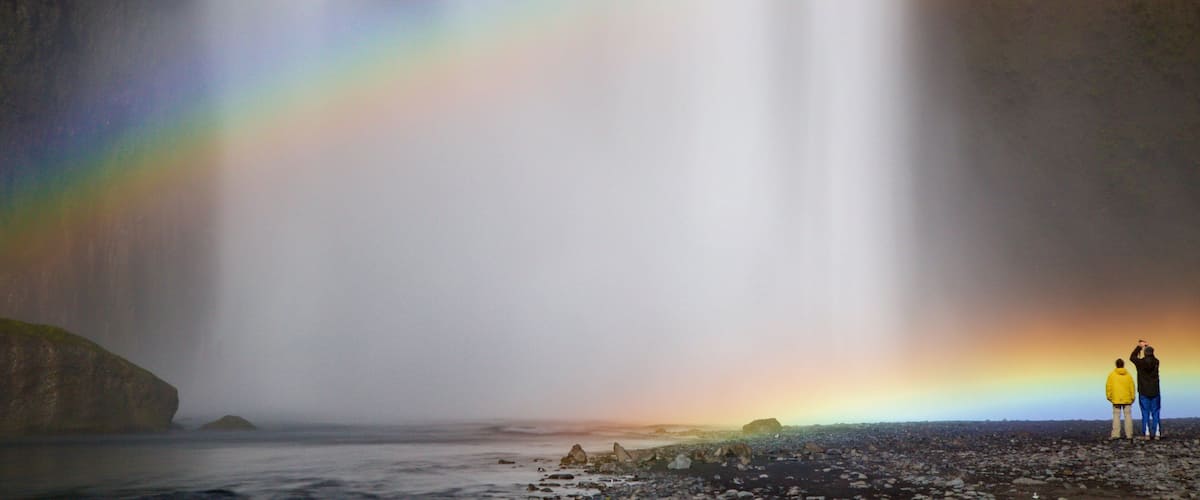 Skogafoss featuring a waterfall as well as a small group of people