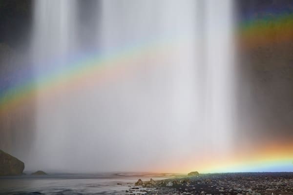 Skogafoss featuring a waterfall as well as a small group of people