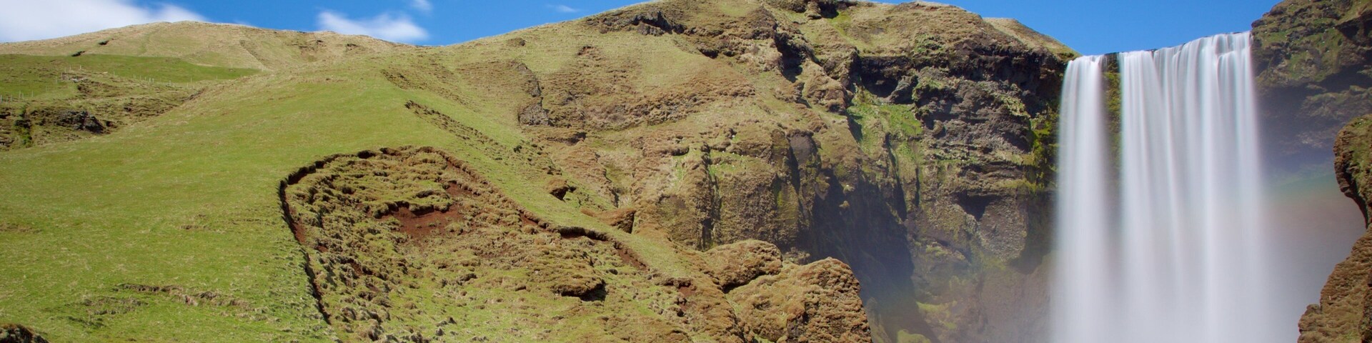 Skogafoss mostrando uma cachoeira e um rio ou córrego