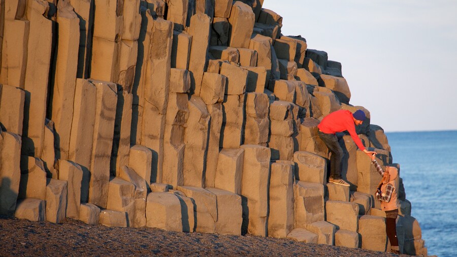 Black Beach featuring a sunset as well as a small group of people