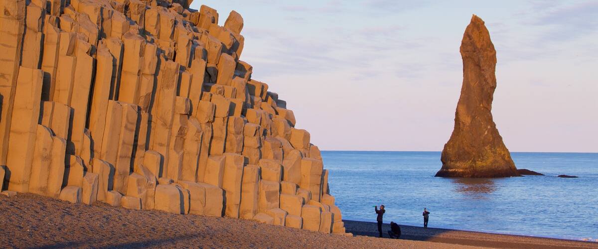Reynisdrangar das einen allgemeine Küstenansicht und Sonnenuntergang