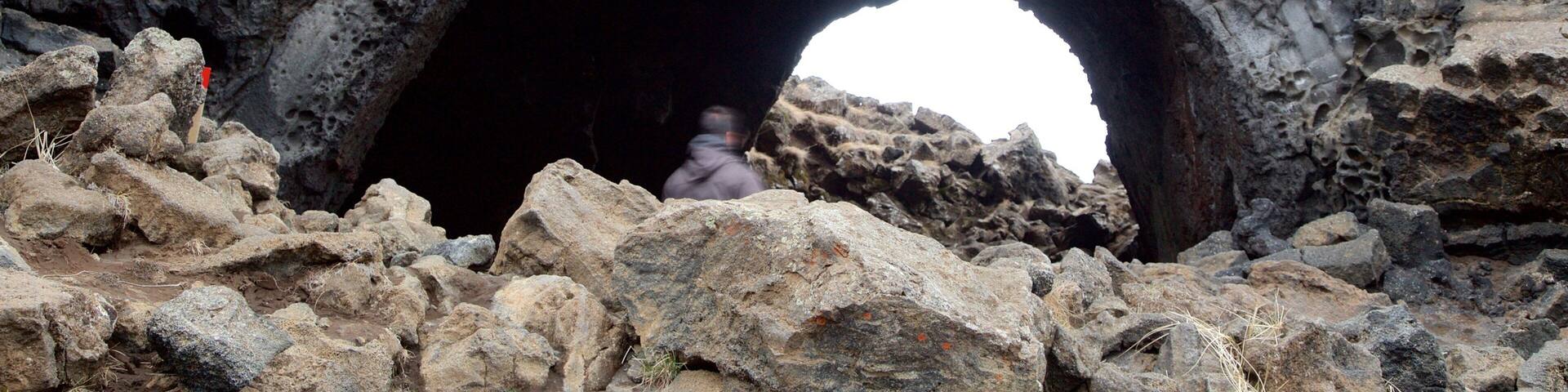 A rocky landscape with a large arch-shaped opening.