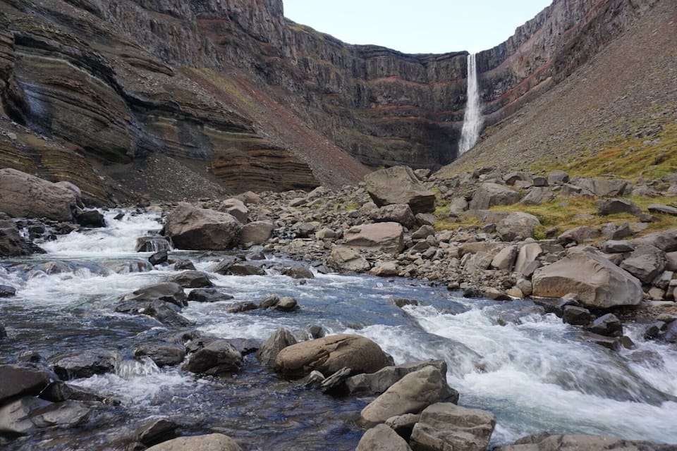 A river flowing through a rocky canyon with a waterfall.