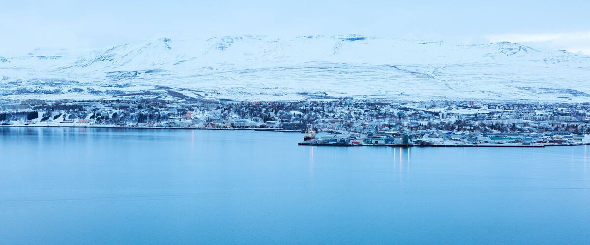 Akureyri, with Hlidarfjall behind, viewed from the eastern shore of Eyjafjordurat dusk in winter, northern Iceland.