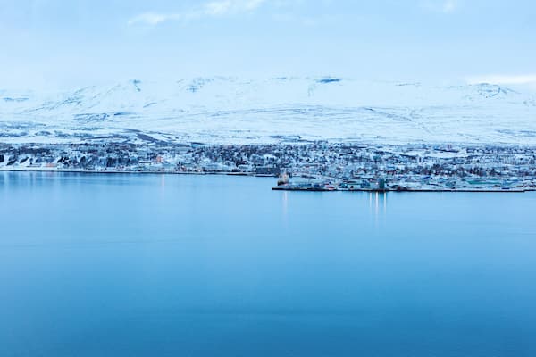 Akureyri, with Hlidarfjall behind, viewed from the eastern shore of Eyjafjordurat dusk in winter, northern Iceland.