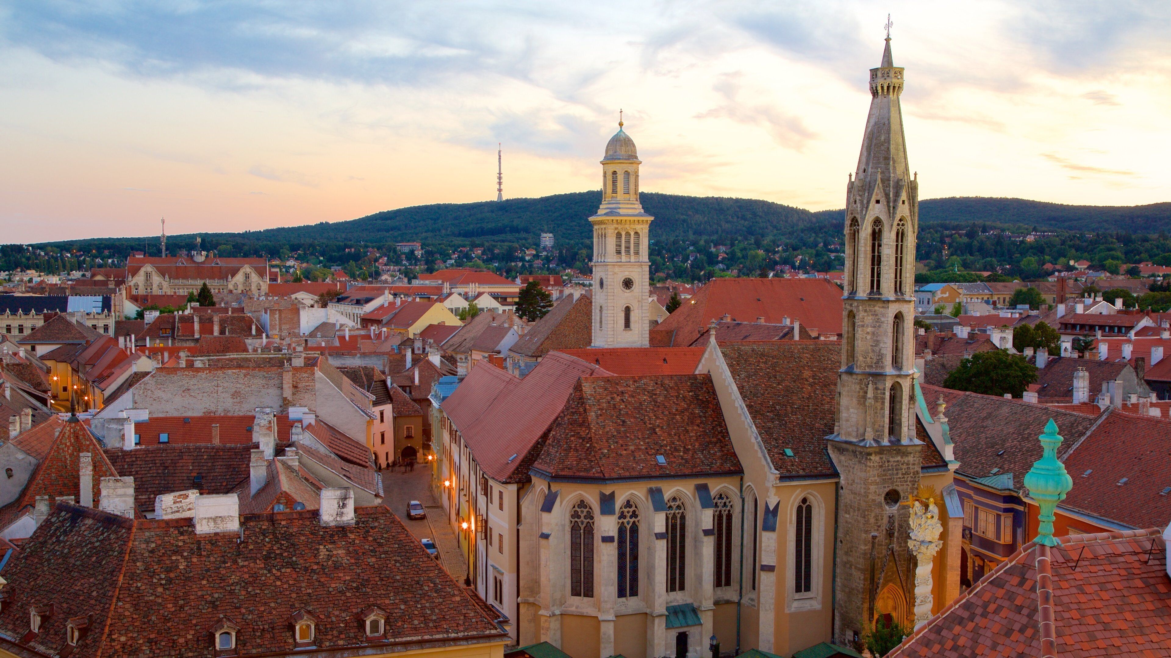 Kecsketemplom que inclui um pôr do sol, uma igreja ou catedral e uma cidade