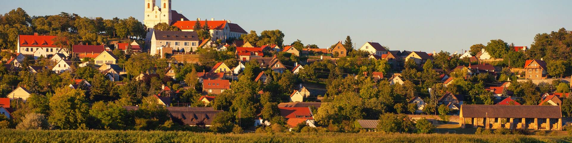 A town with a prominent church and a calm lake reflecting the buildings.