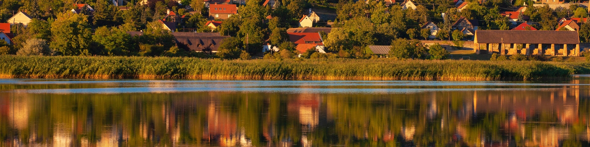 Uma cidade com uma igreja imponente e um lago calmo refletindo os edifícios.