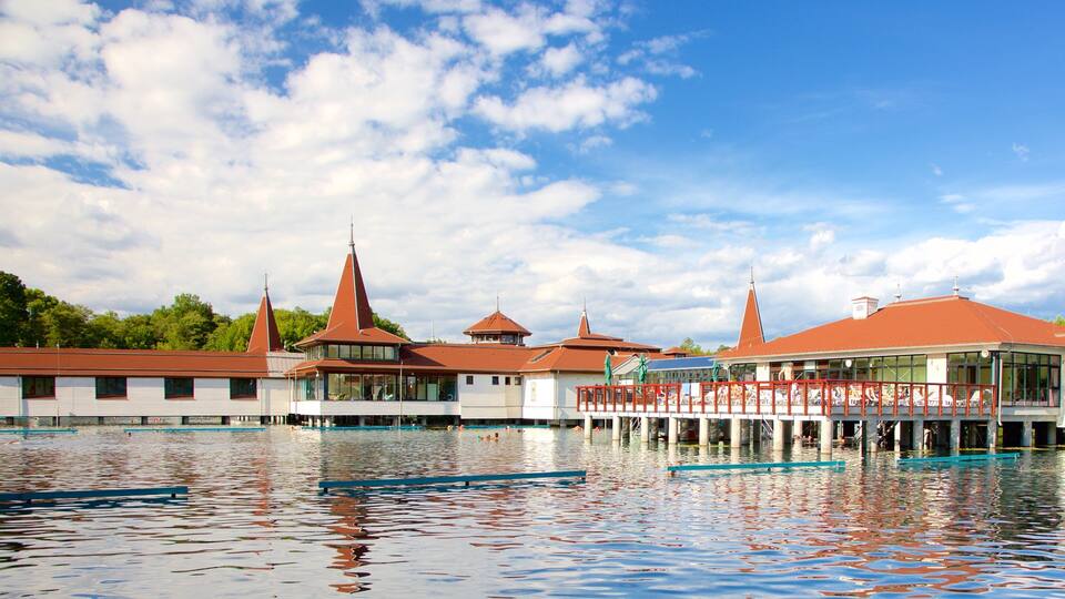 A waterfront building with multiple red-roofed structures and a pool area.