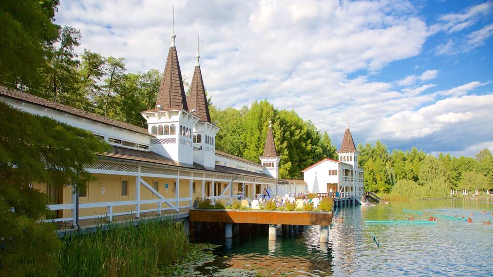 A riverside building with multiple spires and a dock extending into the water.
