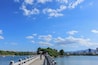 Un pont enjambant une étendue d’eau, avec une vue sur la ville en arrière-plan.