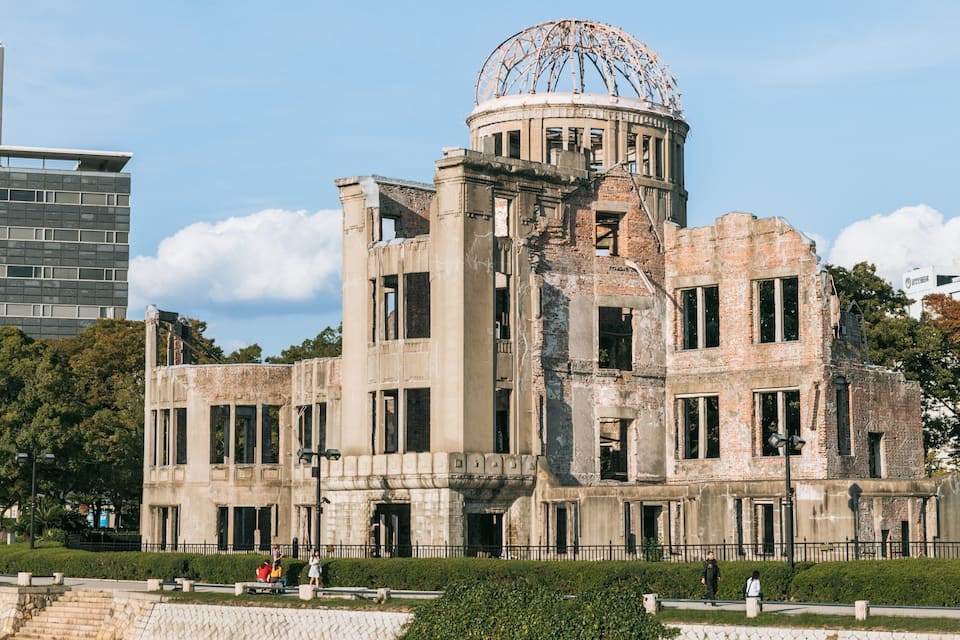 A historic building with a large dome and a modern building in the background.