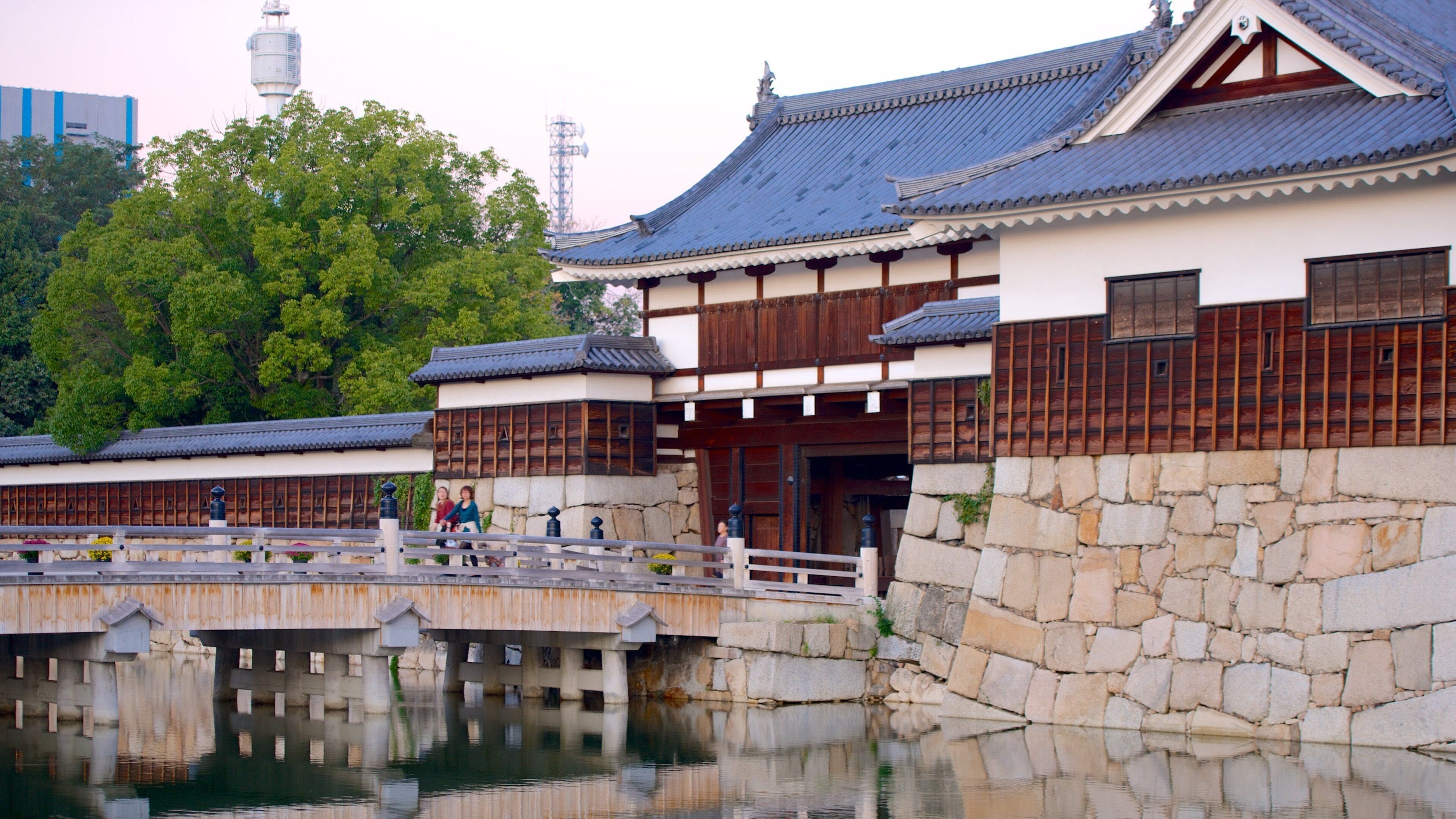 Traditional Japanese architecture with wooden buildings and a stone wall.