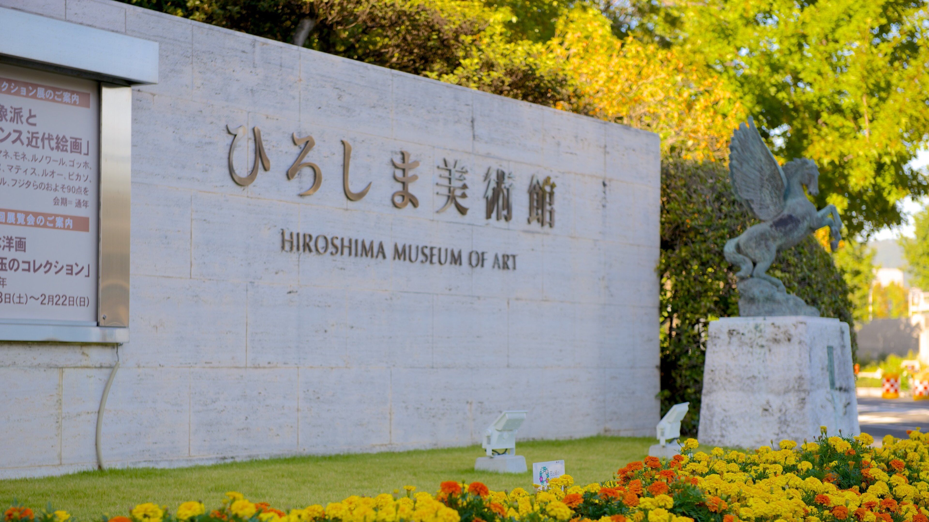 Museo de Arte de Hiroshima que incluye flores, señalización y una estatua o escultura