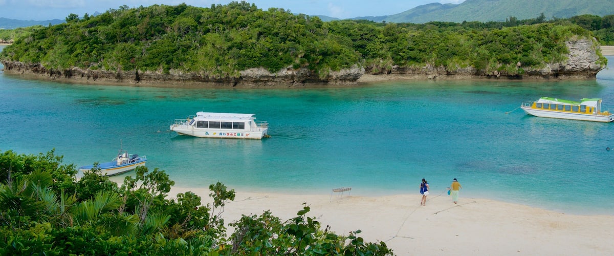 Kabira Bay Beach which includes a sandy beach and boating as well as a small group of people