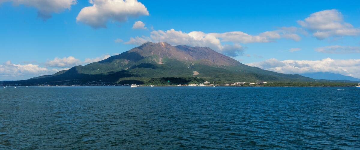 A mountain with a lake in the foreground and a clear sky.