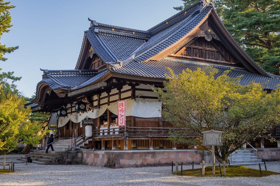 Um edifício japonês tradicional com telhado de telhas e estrutura de madeira.