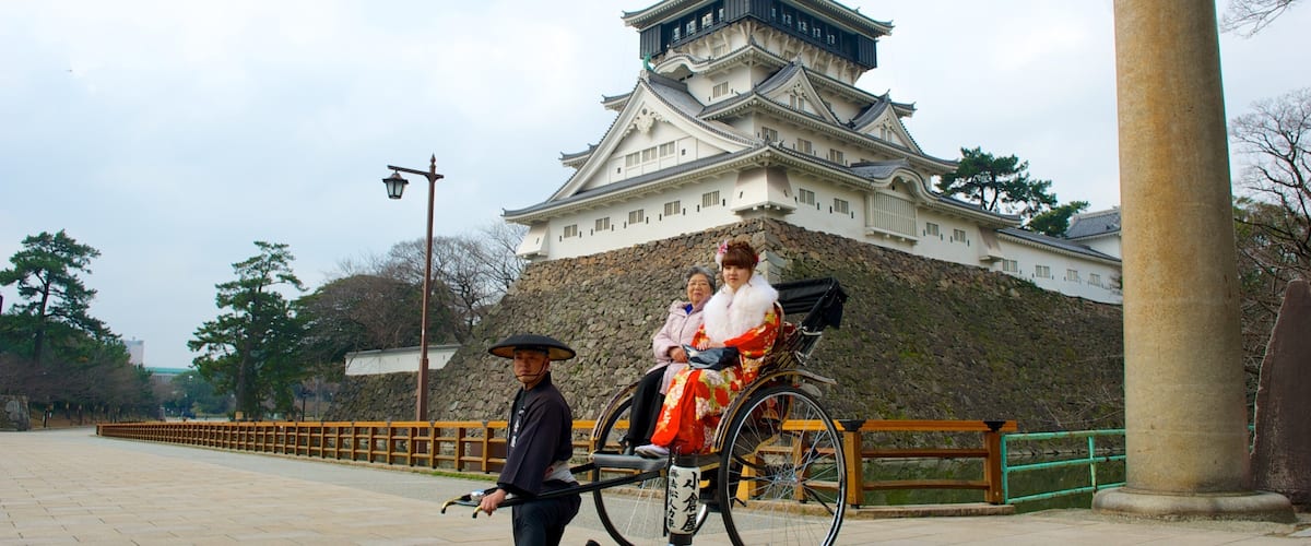 Kokura Castle showing château or palace and street scenes as well as a small group of people