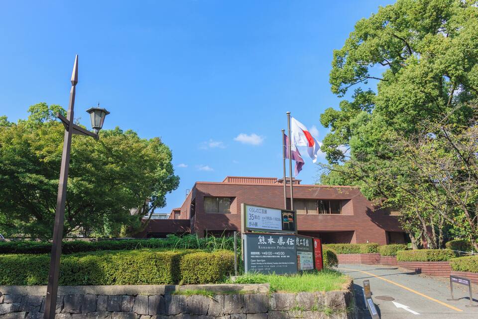 A building with a signboard, a flag, and a street lamp.