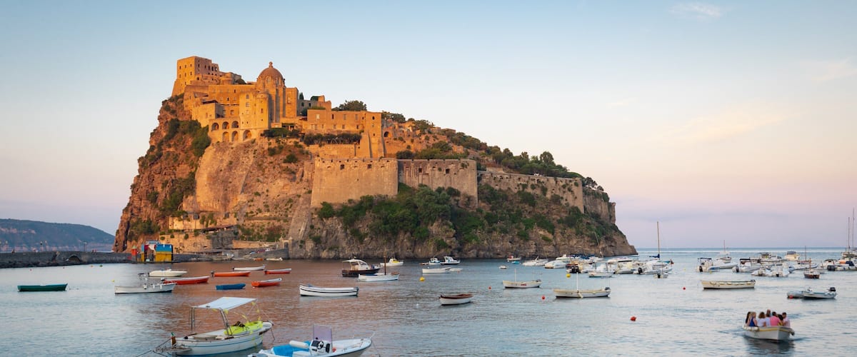 Aragonese Castle which includes heritage elements, general coastal views and a sunset