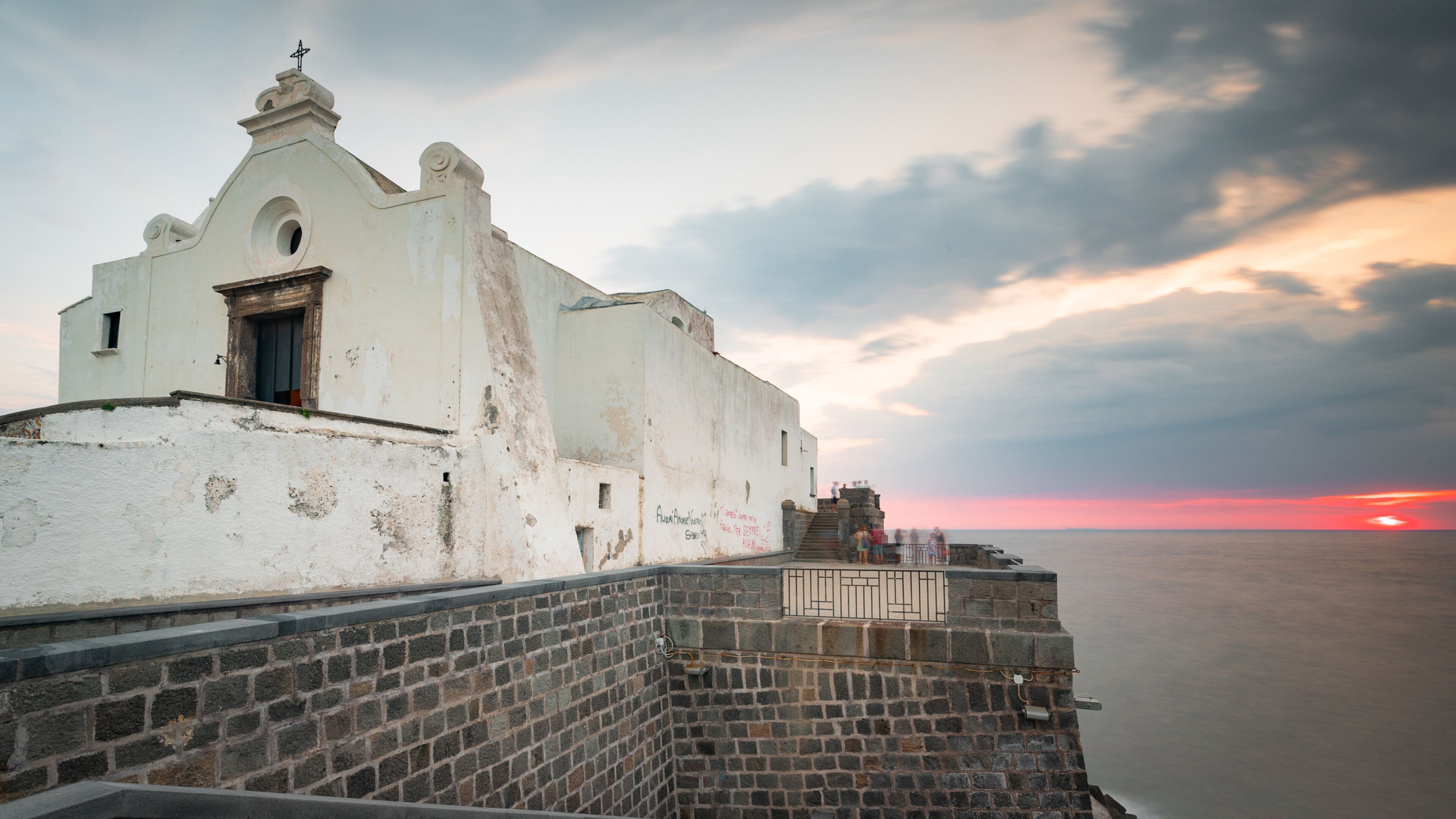 Soccorso Church which includes a sunset, heritage architecture and general coastal views