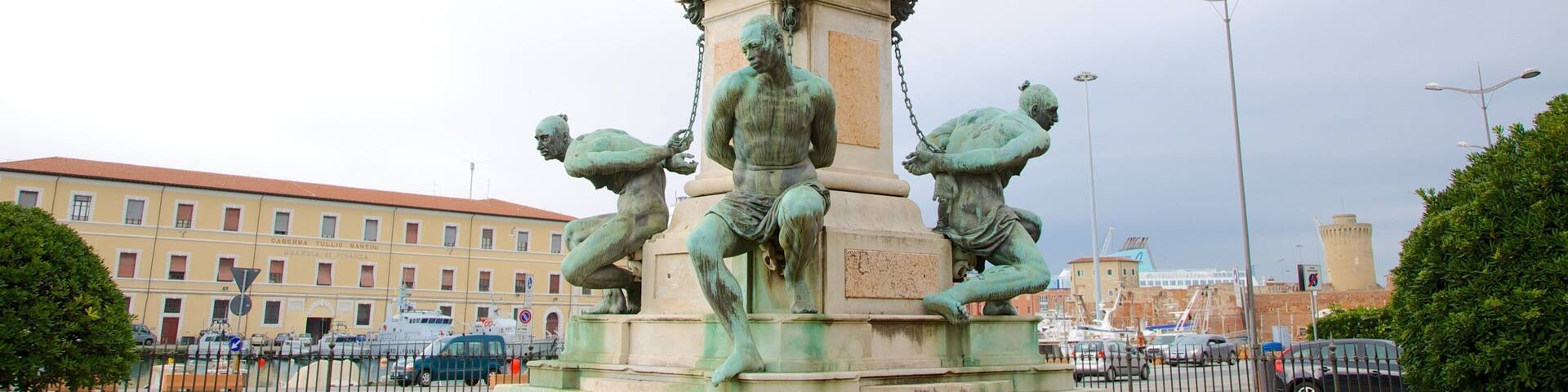A statue of a man in armor with a sword, surrounded by four bronze figures.