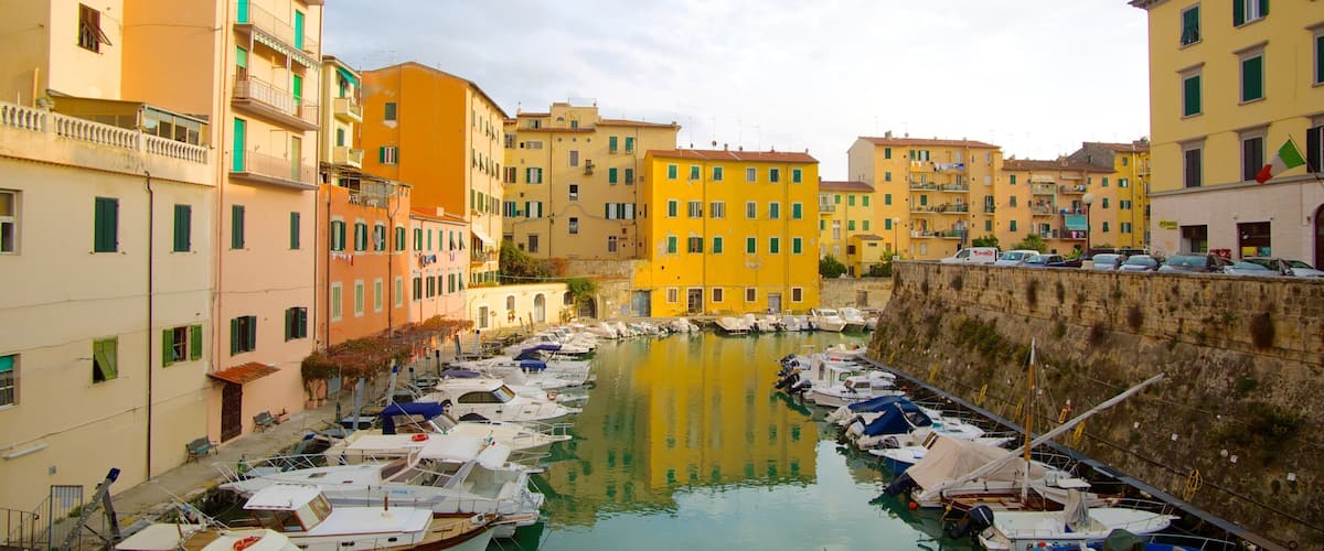 A marina with boats docked, surrounded by colorful buildings.