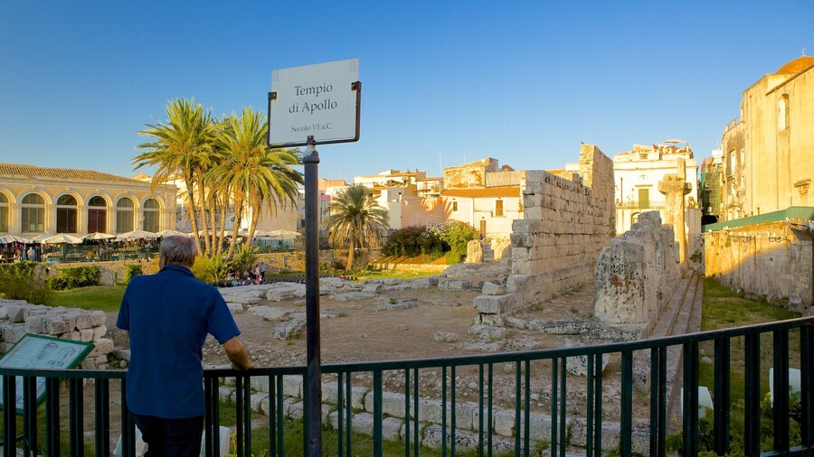 Templo de Apolo que incluye elementos del patrimonio y una ruina y también un hombre