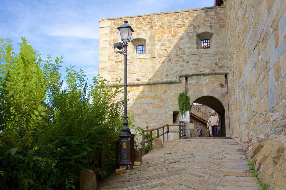 A stone pathway leading to a historic building with arched windows and a lantern post.