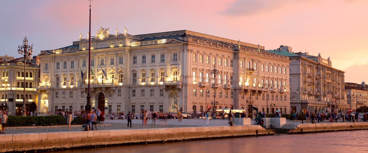 Piazza dell\'Unita mostrando una puesta de sol, un parque o plaza y un edificio administrativo