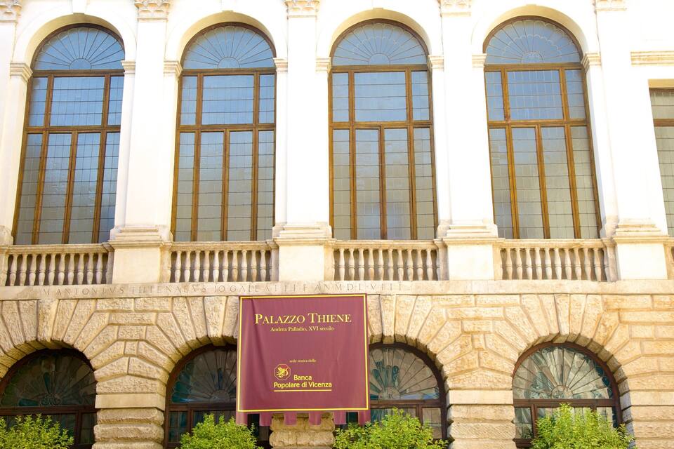 A building with arched windows and a banner reading "Palazzo Thiene".