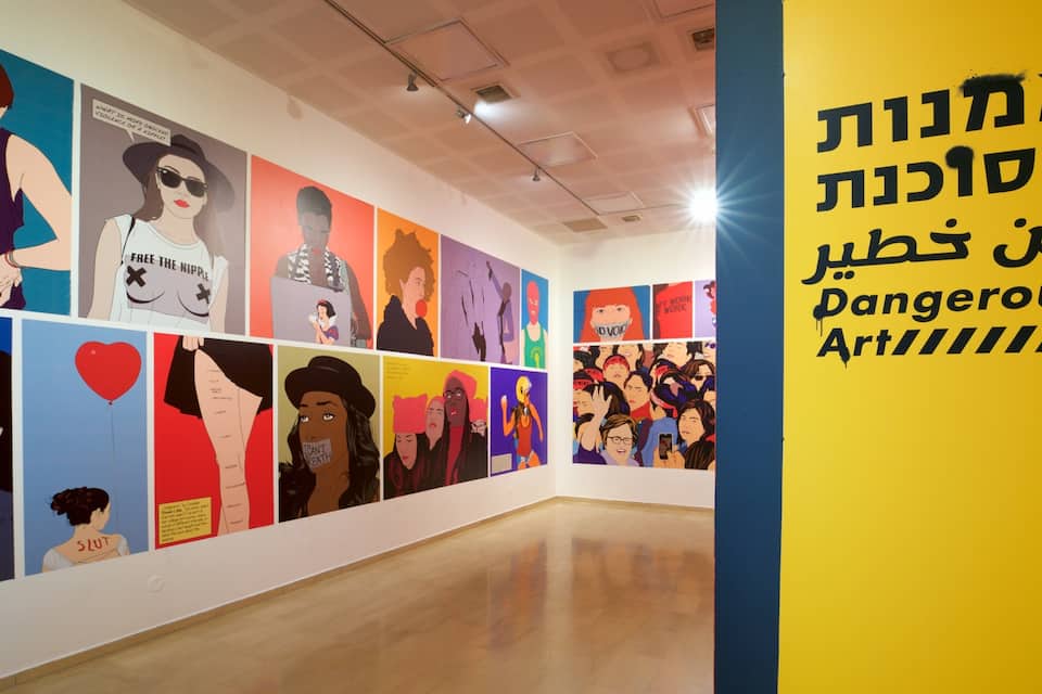 An art gallery with various colorful artworks on display.