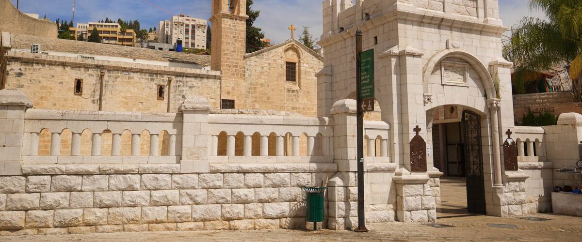 A historic stone building with a bell tower and arched windows.