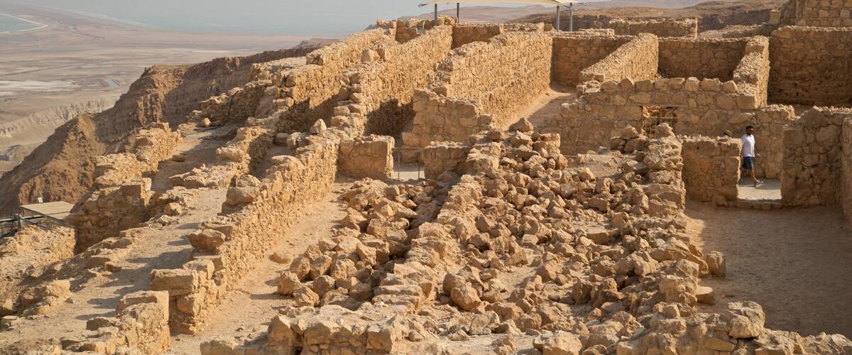 Ancient stone ruins with a person standing near the entrance.