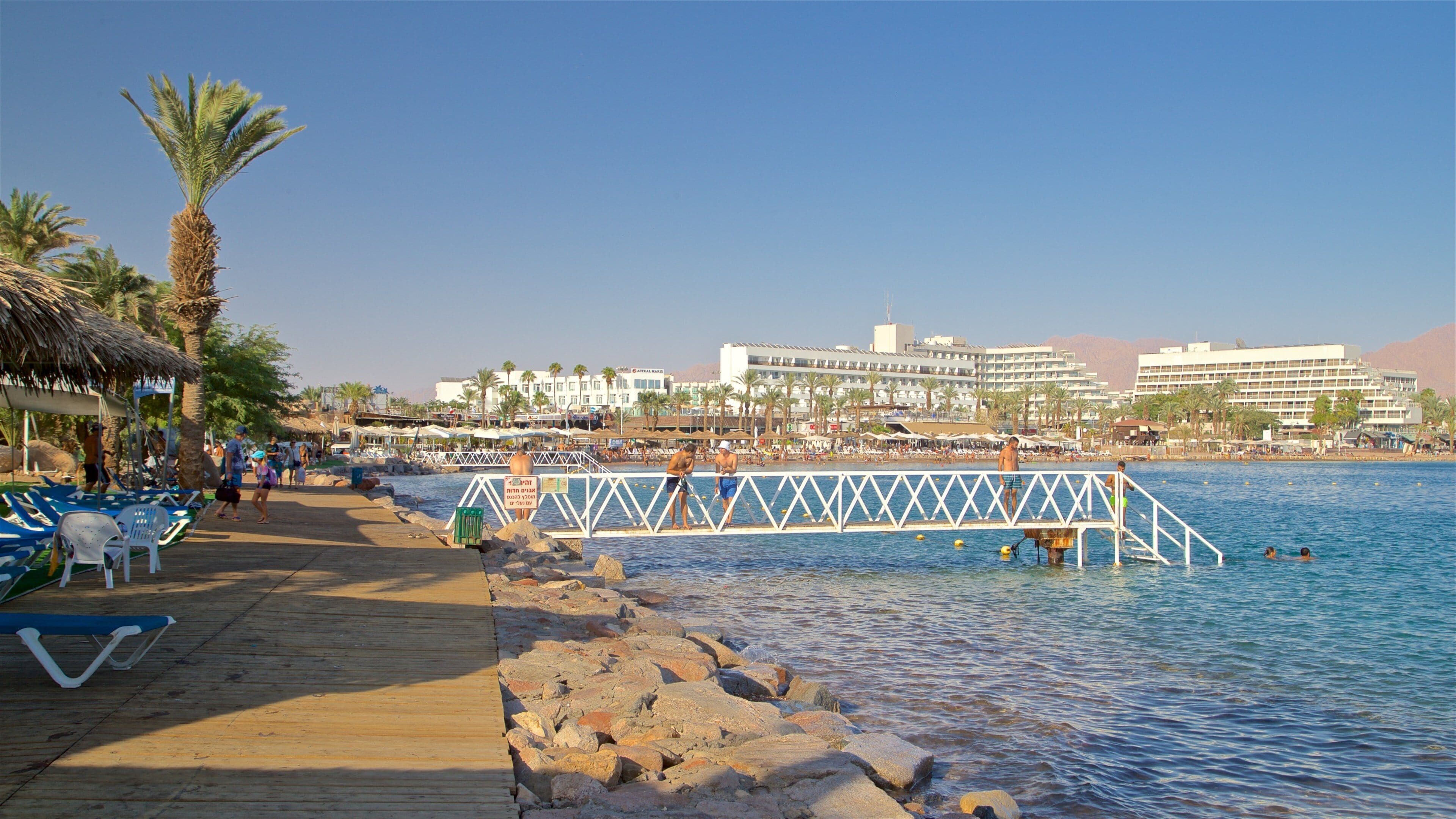 Green Beach showing a coastal town and general coastal views as well as a small group of people
