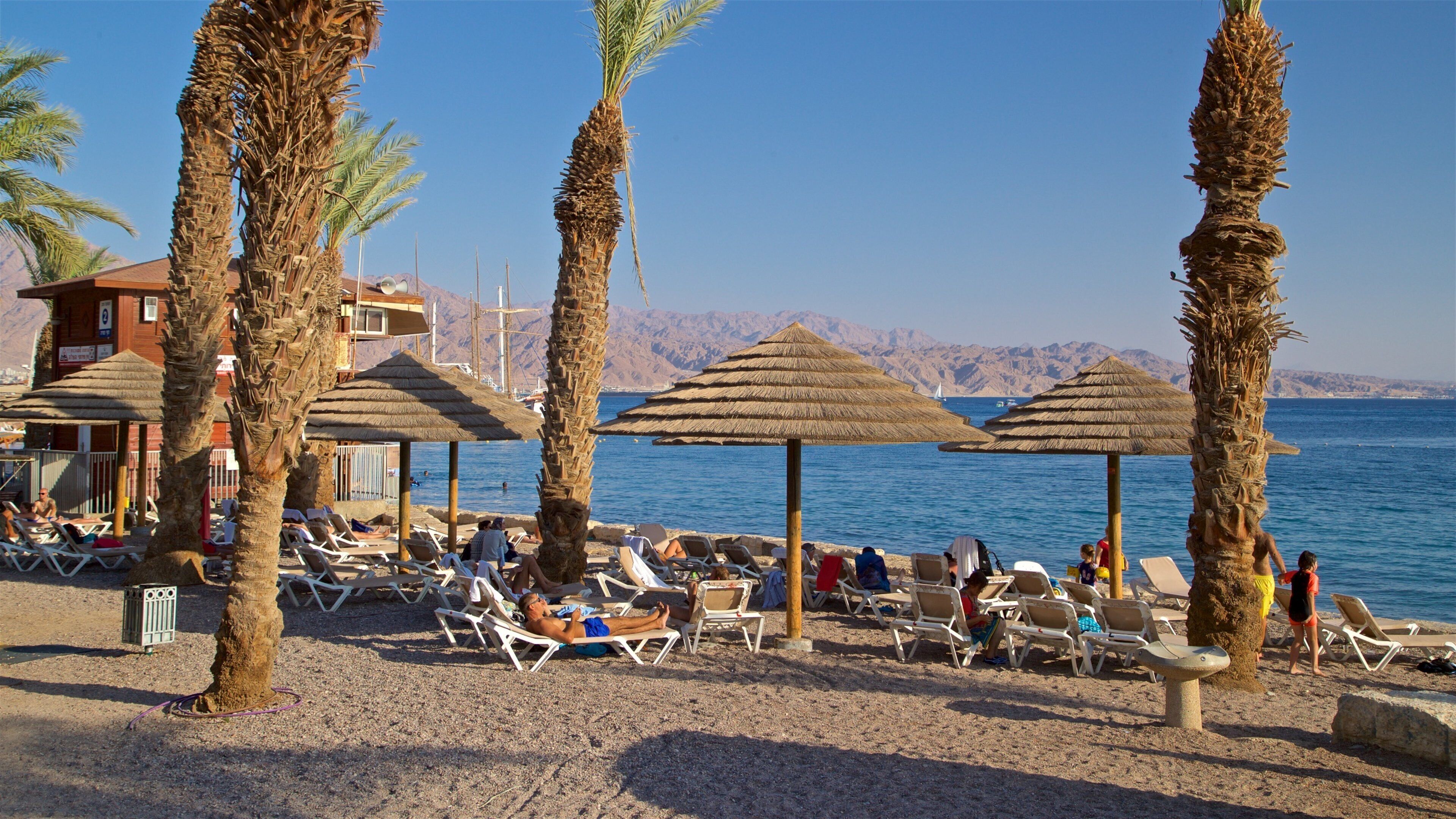 Green Beach som inkluderer kyst og sandstrand i tillegg til en liten gruppe med mennesker