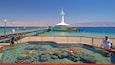 Une jetée surmontée d’un phare, une eau d’un bleu limpide et un récif corallien.