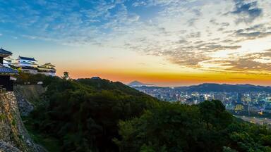 Arquitetura japonesa tradicional, paisagem urbana e um pôr do sol.