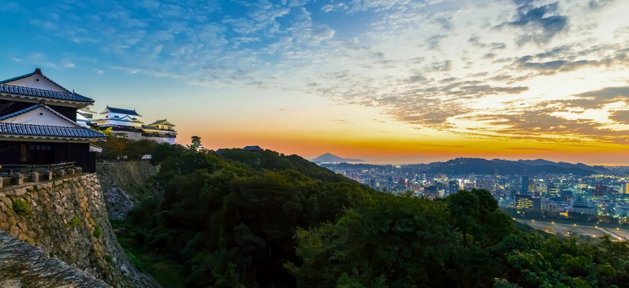 Arquitetura japonesa tradicional, paisagem urbana e um pôr do sol.