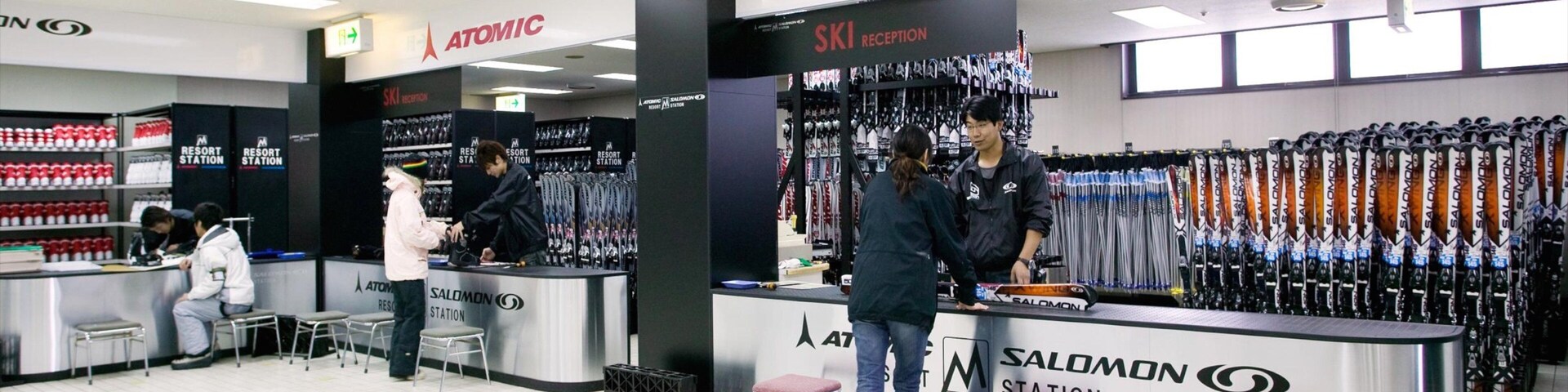 Tienda de equipo de esquí con múltiples mostradores y una zona de recepción para esquiadores.